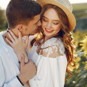 Sunflower field. Couple in a summer field. Girl in a white dress