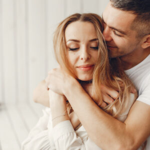 Cute and elegant family in a white rom Couple sitting at home. Beautiful blonde with her husband. Man in a white shirt